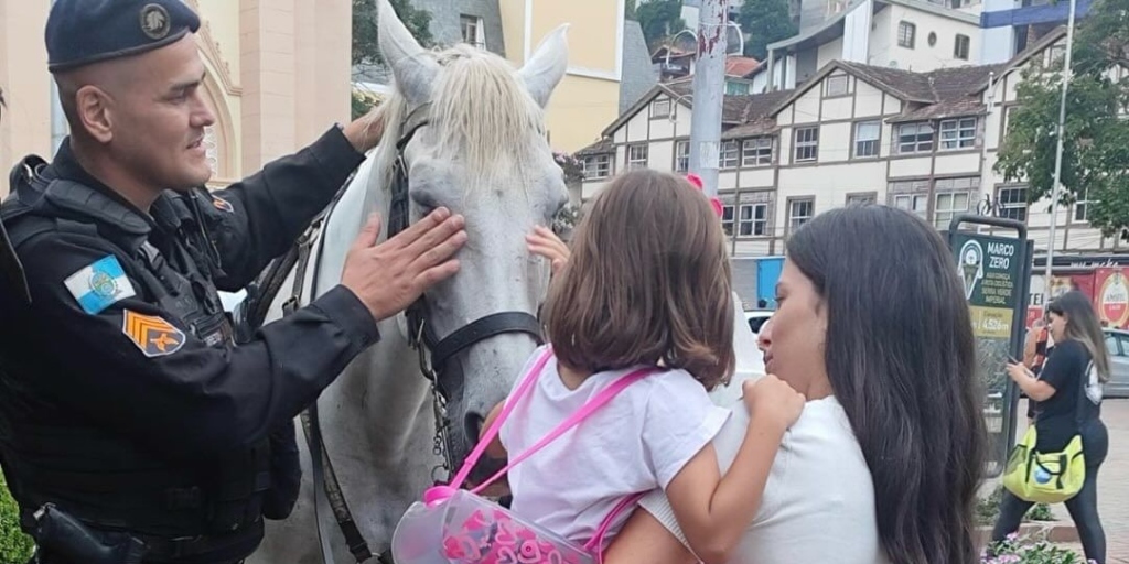 Criança brincando com cavalo da Polícia Montada